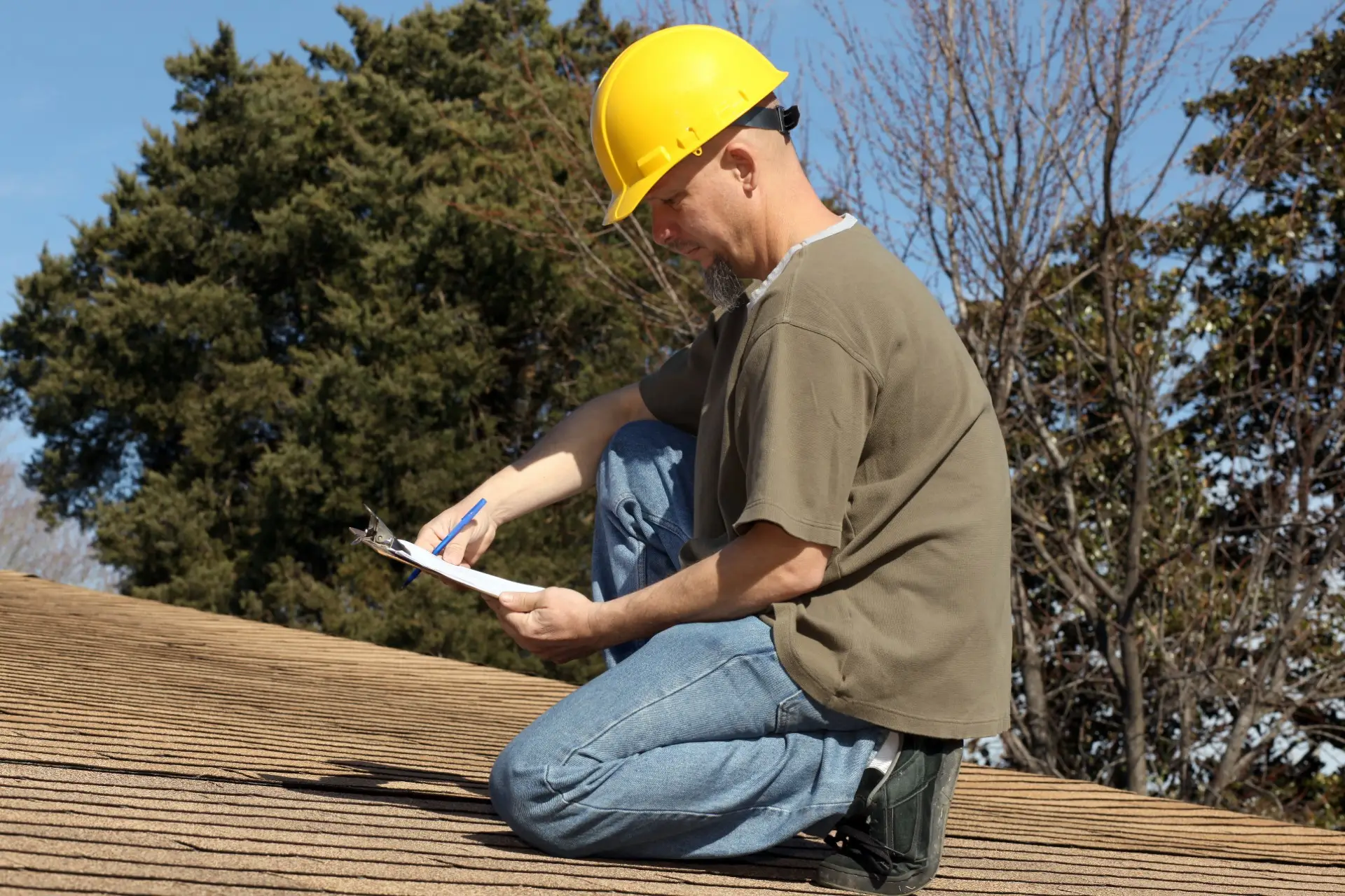Contractor with clipboard inspecting roof in Tucson